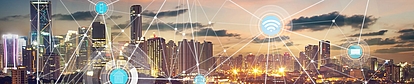 Réseau urbain intelligent avec icônes du spectre sans fil au coucher du soleil Skyline de ville illuminée avec des symboles de connectivité sans fil représentant la régulation moderne du spectre.