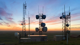 Radio towers at sunrise representing software tools for planning and optimizing wireless networks.
