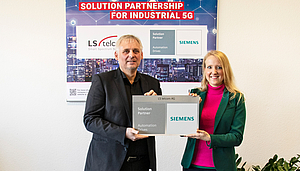 Deux personnes tenant une pancarte annonçant LS telcom AG comme partenaire de solutions Siemens pour Automation Drives.
