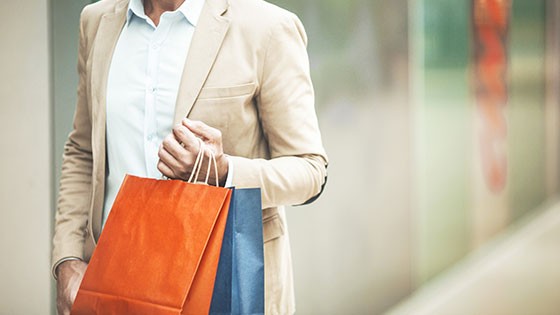 Expérience de shopping à Roppenheim. Un homme tenant des sacs de shopping colorés dans un environnement commercial moderne.